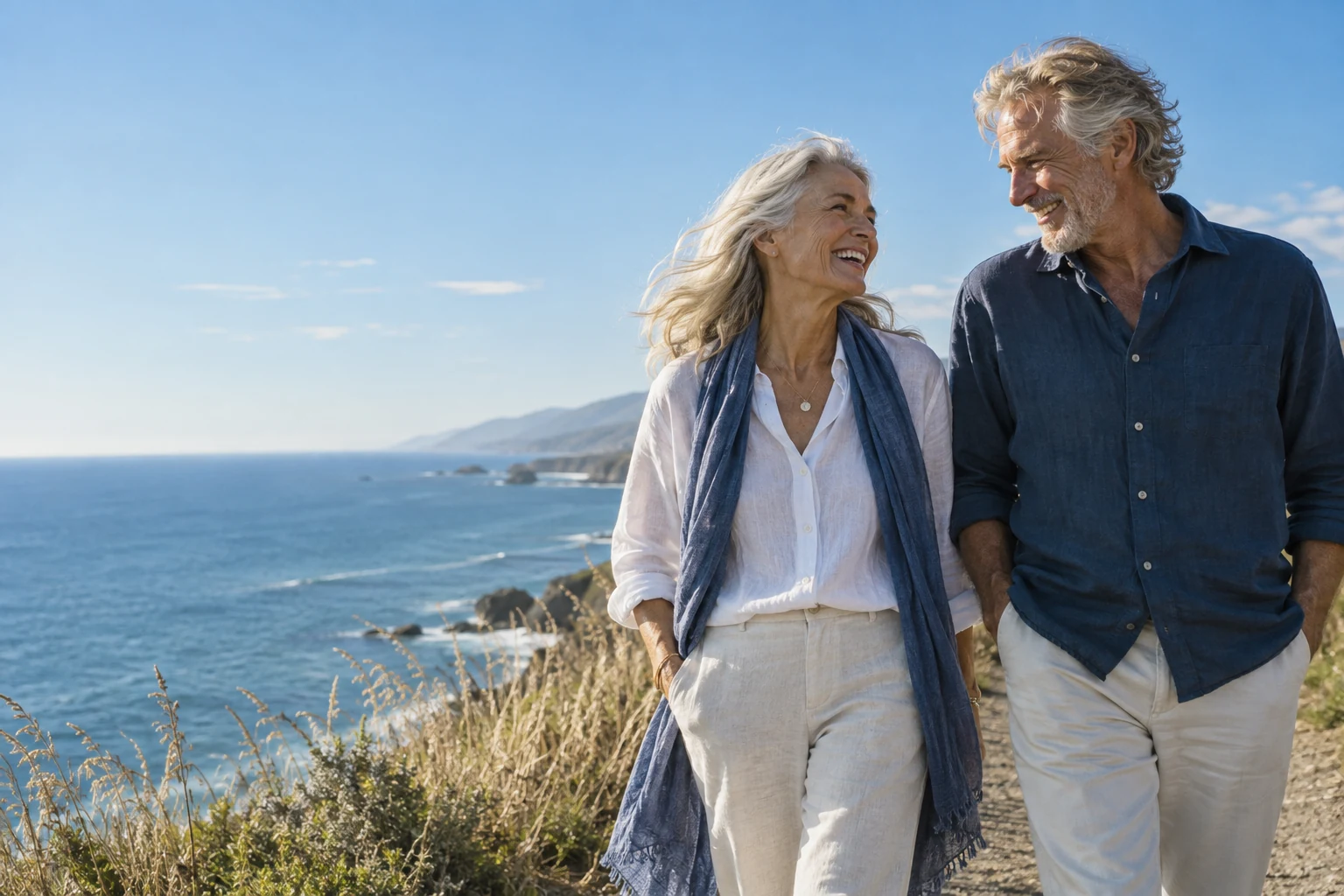 An older couple walking beside the ocean